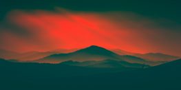 Silhouette of a mountain range under a dramatic red sky.