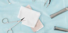 Medical instruments and gauze on a sterile blue surface.