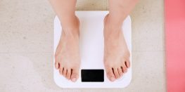 Close-up of a person's bare feet on a white digital bathroom scale.