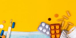 Medical supplies including pills, capsules, and a protective mask on a bright yellow background.